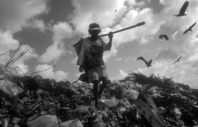 Young Boy Climbing and Picking Through Landfill