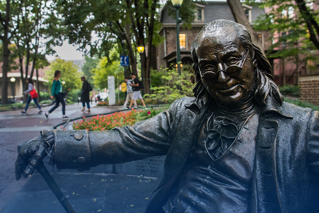 Sculpture of Benjamin Franklin sitting on a bench on Locust Walk