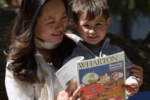 New Wharton MBA mother holding their toddler and Wharton Magazine