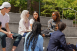 Eight STEP students sitting on stairs and talking