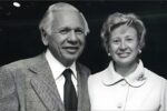 A black and white photo of Leonard and Sophie Davis in formal attire with a dark speckled background.