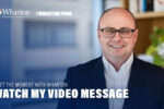 Bill Bole in a navy suit and glasses smiling in an office setting with Wharton branding. "Watch My Video Message"
