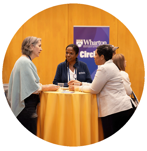 Three Wharton alumni gathered at a table talking at circles event.