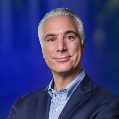 Professor Kevin Werbach in formal attire against a blue background.