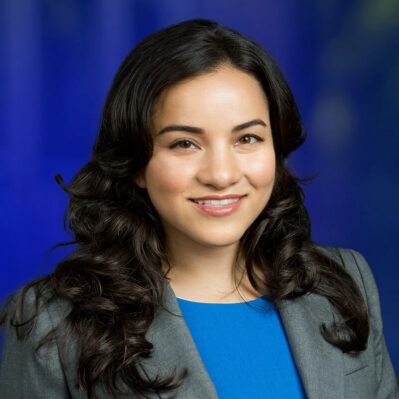 Corrine Low wearing a blazer and smiling