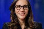 Shiri Melumad wearing glasses in front of a blue background