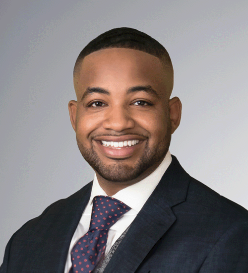 James Walker smiling wearing a tie and blazer