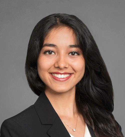 Ruhi Jain wearing a blazer and smiling