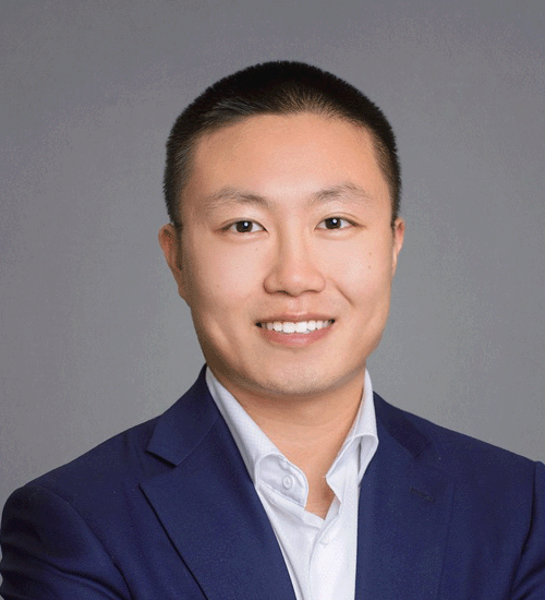 Shawn Song wearing a blazer and smiling