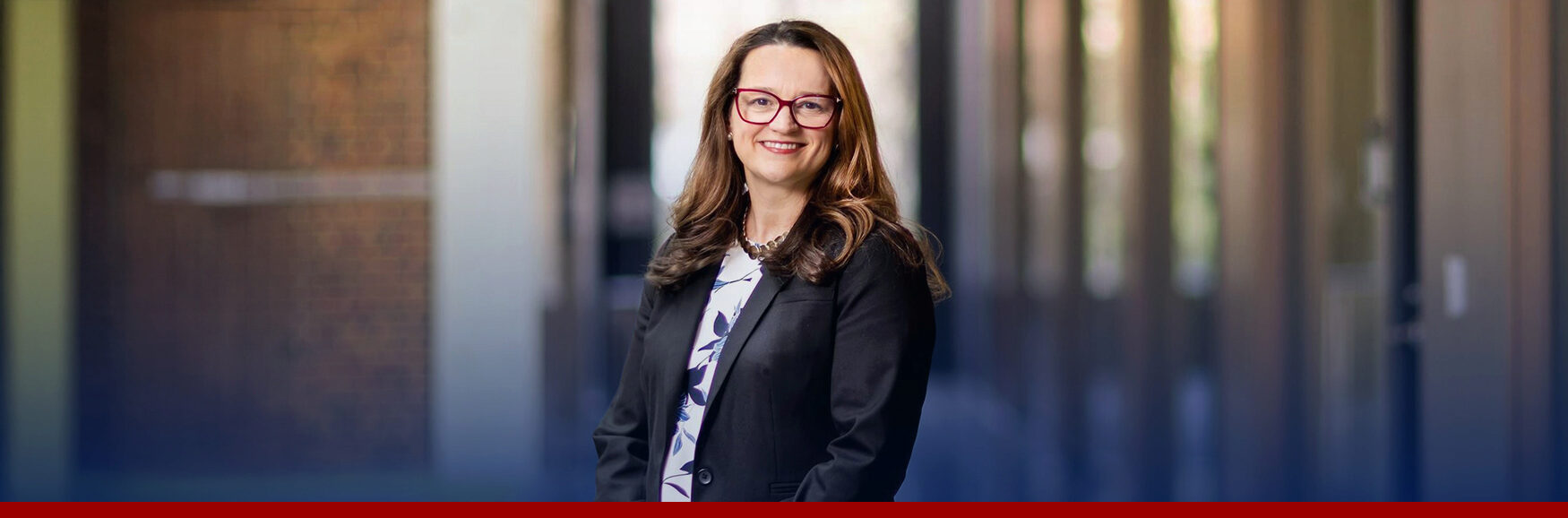 Colleen O'Neill poses for a headshot in a Wharton building.
